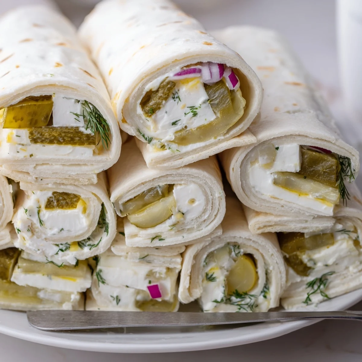 Crispy Pickle-in-a-Blanket snack with creamy filling, perfect for festive gatherings.  