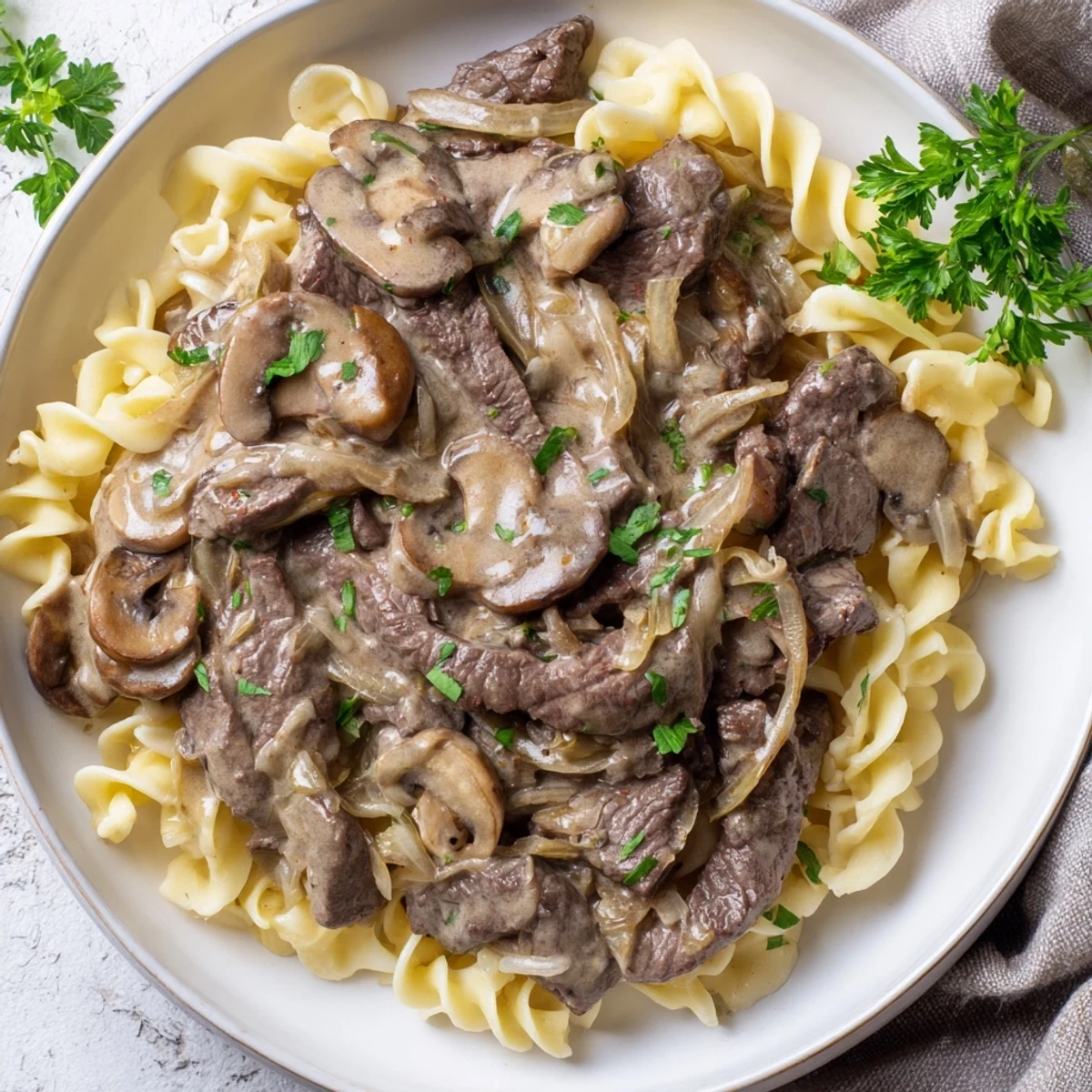 Creamy Mushroom Beef Stroganoff: a close-up of tender beef and mushrooms in a rich, creamy sauce.
