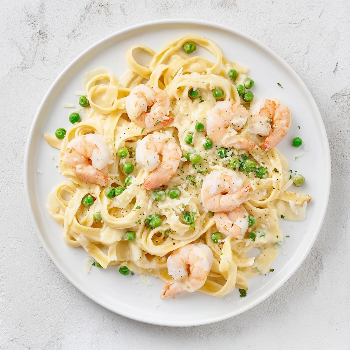 A close-up of finished Instant Pot Shrimp Alfredo Pasta, garnished with fresh parsley on a white plate.