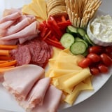 This easy budget-friendly family spread showcases vibrant meats and cheeses alongside crisp veggies, ready to enjoy.