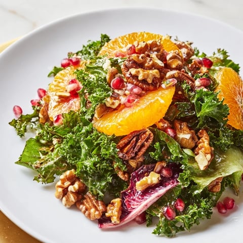 Vibrant Winter Greens Salad with citrus, pomegranate seeds, and toasted nuts, a lovely colorful dish.
