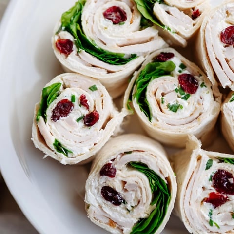 Golden, spiral cuts of Simplified Turkey Cranberry Pinwheels, ready to serve for a holiday gathering.