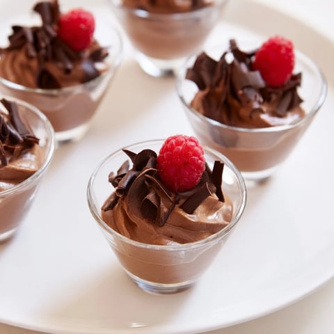 Elegant chocolate mousse dessert cups, garnished with fresh berries, ready for a special occasion.