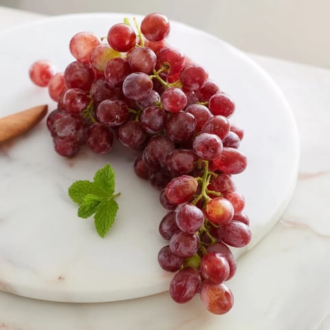 Sweet, juicy grapes spilling from a wooden board, ready for a refreshing snack.