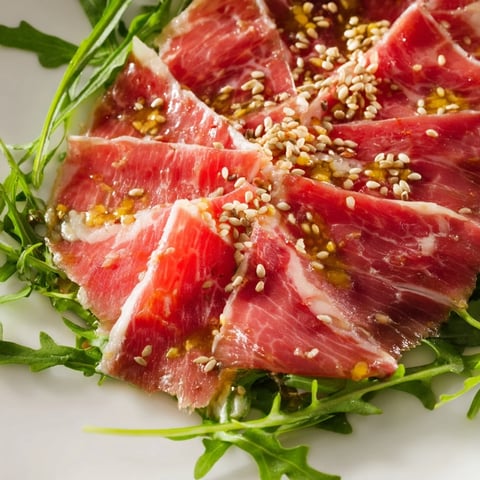 Delicate beef Origami Folds, beautifully arranged with arugula, sesame seeds, and Parmesan for serving.