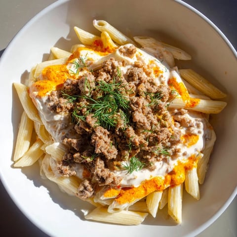 Steaming Turkish pasta with ground turkey is shown drizzled with paprika butter, ready to serve and enjoy.