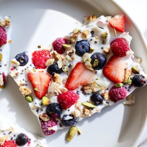 Colorful, frozen fruit yogurt bark with berries and nuts, a healthy snack bursting with flavor.