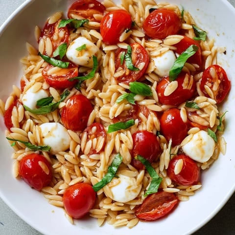 Bright Caprese Orzo Salad with juicy tomatoes, mozzarella, and a tangy balsamic dressing, ready to enjoy.