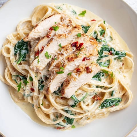 Golden-brown Cajun Chicken Spinach Alfredo Pasta twirled in a rich, cheesy Alfredo sauce.