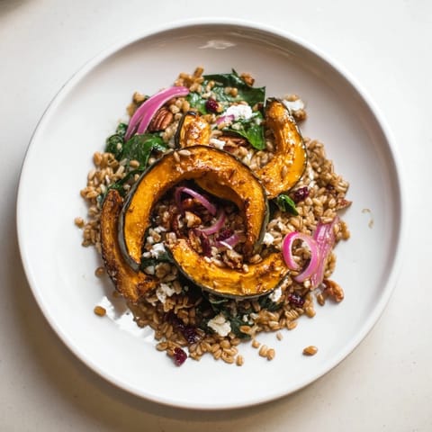 A beautiful, colorful bowl of farro & mustard green salad with roasted squash and delicious dressing.