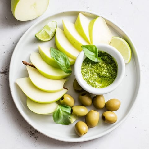 A colorful Emerald City appetizer with green olives, lime wedges, and a pesto dip; perfect for sharing.