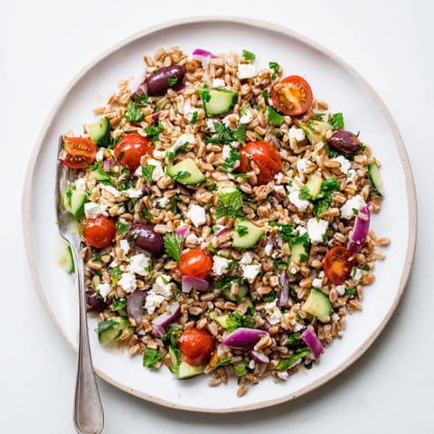 Farro Salad Mediterranean tossed in a zesty lemon-oregano dressing, featuring fresh parsley, mint, and red onion, making a refreshing vegetarian side dish for a sunny picnic.  