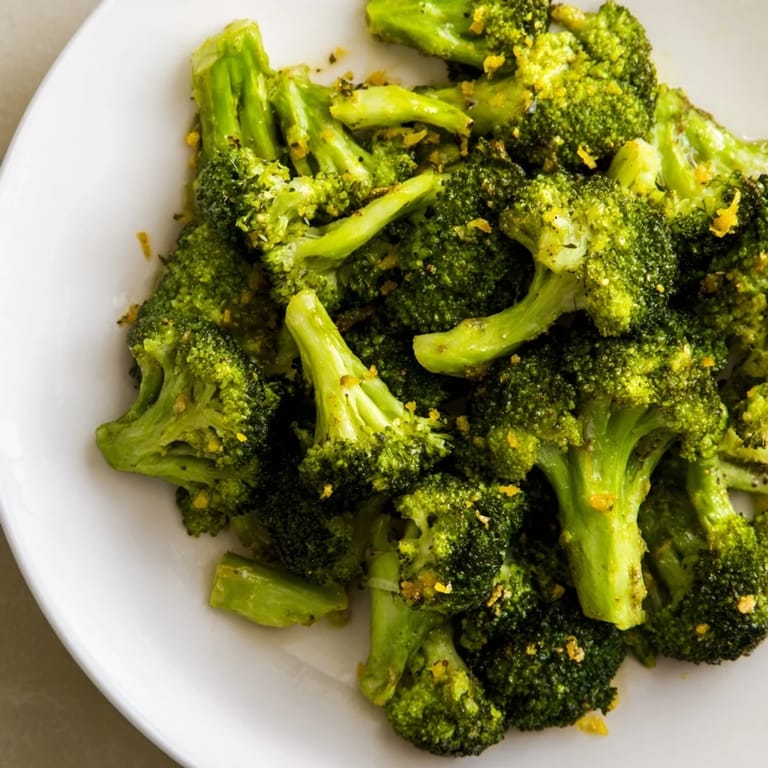 A colorful plate of Lemon Garlic Roasted Broccoli with lemon zest, smelling savory and ready to enjoy.