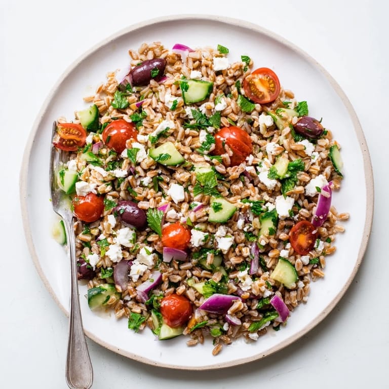 Farro Salad Mediterranean tossed in a zesty lemon-oregano dressing, featuring fresh parsley, mint, and red onion, making a refreshing vegetarian side dish for a sunny picnic.  