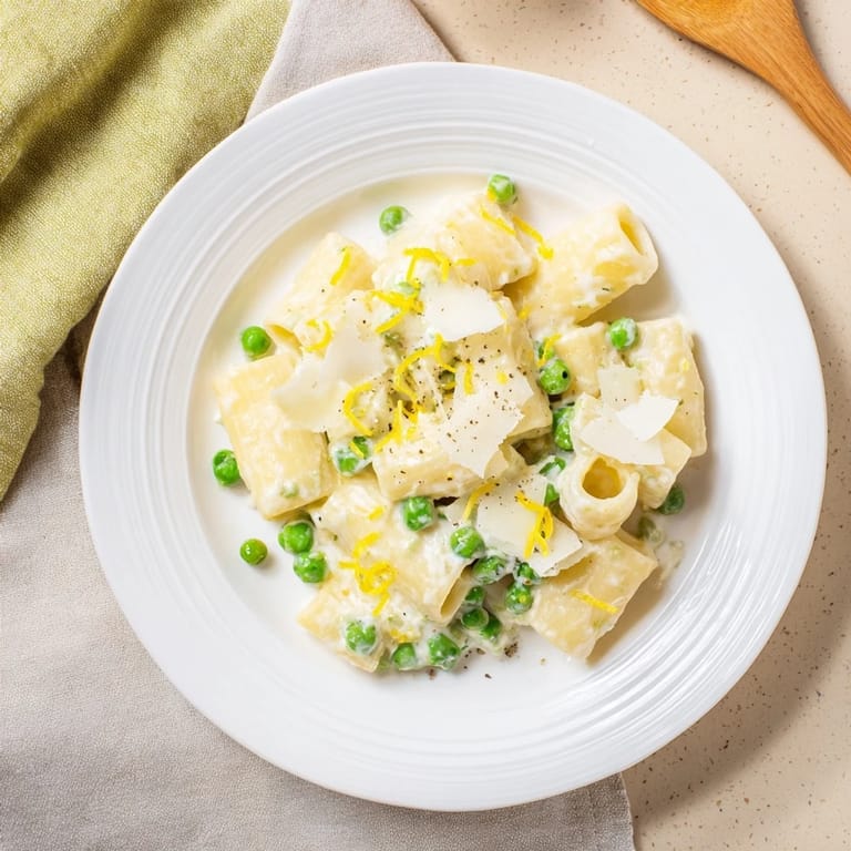 Steaming rigatoni tossed with ricotta, peas, and lemon juice makes a light Pea & Lemon Ricotta Pasta, perfect for spring weeknight dinners.